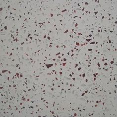 a white wall with red and black speckles on it