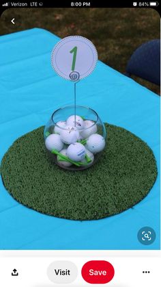 a glass bowl filled with golf balls sitting on top of a green tablecloth covered field