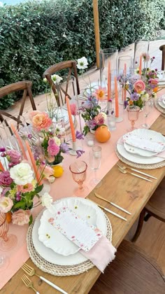 an outdoor table set with plates and place settings