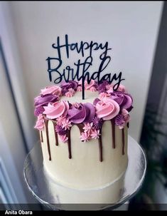 a birthday cake decorated with pink and purple flowers