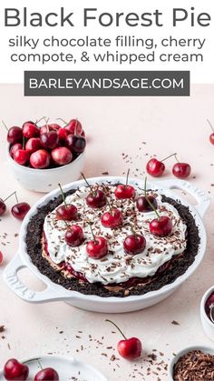 a pie with cherries and whipped cream on top, surrounded by bowls of cherries