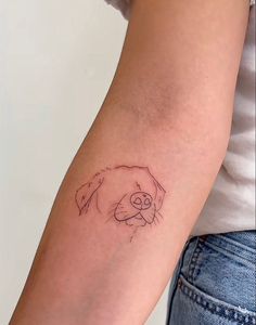 a woman's arm with a small tattoo of a dog on the left side of her arm