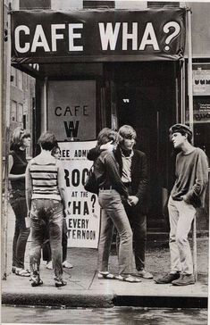 a group of people standing in front of a cafe with a sign that says cafe wha?