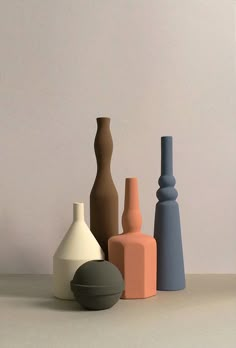 several different colored vases sitting next to each other on a white counter top in front of a gray wall