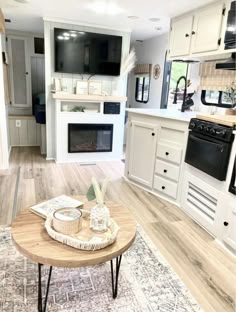 a living room and kitchen area in a home with white cabinets, wood floors and an open floor plan