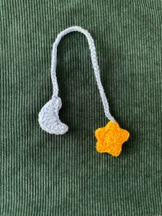 a crocheted star ornament hanging from a cord on a green sweater