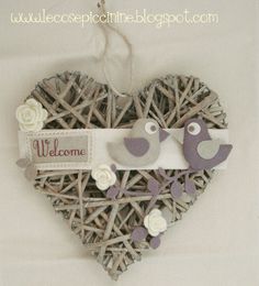 a heart shaped decoration with two birds on it's side and the words welcome