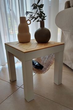 two vases sitting on top of a wooden table