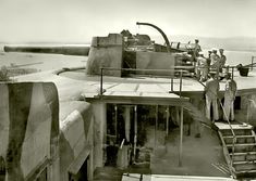 an old photo of men standing on top of a large plane in the air with stairs leading up to it