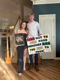 a man and woman standing next to each other holding signs that say i am wait to cump more memories with you go to prom