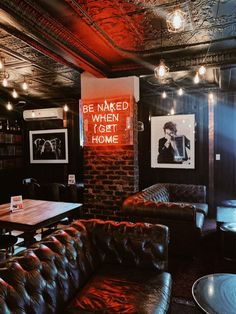 a dimly lit room with leather couches and tables