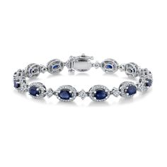 Inspired by the watercolor artistry of REEDS matriarch and co-founder, Roberta Zimmer, the exclusive Roberta Z Watercolor Collection is awash in vivid hues and luminous detail. In this collection, we celebrate her spirit and the grace and fortitude of women everywhere. Crafted in gleaming 14k white gold, this stunning tennis bracelet features an elegant row of oval-shaped blue sapphire gemstones that are surrounded by round diamonds in a halo design. The diamonds are 2ctw, I in color, and I1 in Oval White Gold Sapphire Bracelet, Elegant Sapphire Tennis Bracelet With Oval Shape, Elegant Oval Sapphire Diamond Bracelet, Blue Oval Sapphire Tennis Bracelet, Elegant Sapphire Gemstone Tennis Bracelet, Blue Sapphire Bracelet, Wedding Day Jewelry, Gold Bangles Design, Bangle Designs