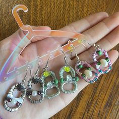 a person holding several pairs of earrings in their hand