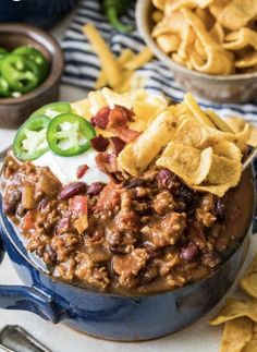 chili cheese and beans in a blue pot with tortilla chips on the side