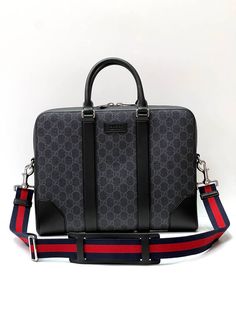 The GG motif in a distinct black/grey combination is further enriched with the Web strap and black leather trims. The slim briefcase is secured with a double zipper closure. Black/grey GG Supreme canvas, with black leather trim Blue and red Web strap Palladium-toned hardware Gucci trademark leather tag detail One gusset Interior zipper and smartphone pockets Padded iPad compartment Double leather handles with 9cm drop Detachable and adjustable nylon strap with 48cm drop and leather shoulder pad Gucci Briefcase Men, Grey Combination, Men's Briefcase, Red Web, Leather Tag, Briefcase For Men, Gucci Leather, Leather Handles, Exclusive Bag