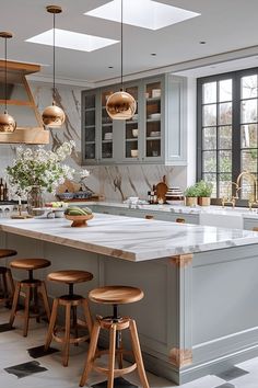 a large kitchen with marble counter tops and wooden stools in front of the island