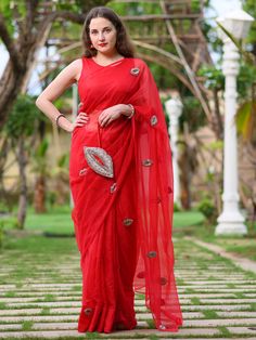 This is a three-piece red lip saree set from the Ensembles collection. The red lip saree is paired with a red sleeveless blouse. The blouse has a round neckline. There are beautiful lip motifs of shimmer cutdana work all over the saree. This saree set is crafted in semi pure organza fabric. The outfit is completed with a heavily embellished, cutdana work shimmer lip shape handbag. Designer Red Blouse Piece With Sheer Dupatta, Designer Red Pre-draped Saree For Diwali, Red Saree For Evening With Traditional Drape, Red Evening Saree With Traditional Drape, Red Pre-draped Designer Saree For Diwali, Traditional Red Pre-draped Saree For Evening, Designer Red Pre-draped Saree With Self Design, Red Pre-draped Saree With Sheer Dupatta For Designer Wear, Red Pre-draped Saree With Zari Work For Evening