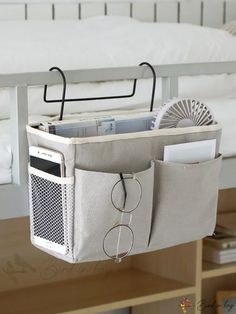 a bed with a white bag hanging from it's side and an air conditioner in the pocket