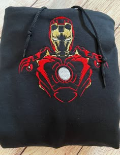 a black bag with a red and gold design on it sitting on a wooden floor