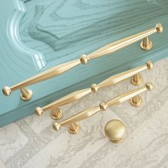 a close up of a blue dresser with gold handles