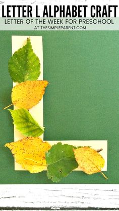 the letter l is made out of paper with leaves attached to it and on top of a