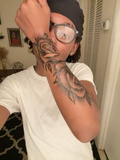 a man with glasses and tattoos on his arm