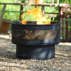 a black fire pit sitting on top of a gravel field