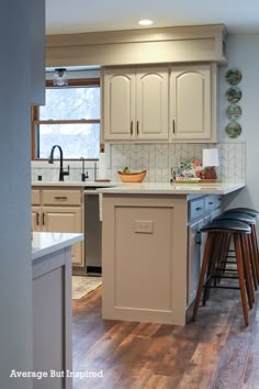 a kitchen with an island and stools in it