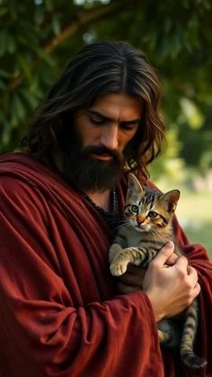 a man holding a cat in his arms while wearing a red robe and long hair