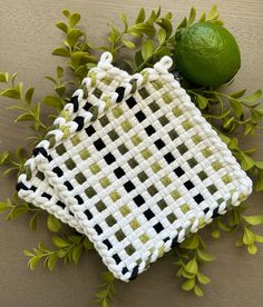 a cross - stitch bag sitting on top of a table next to a lime