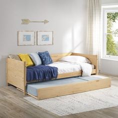 a bed with a pull out trundle in a room next to a window