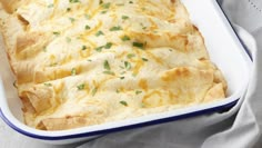 a casserole dish filled with cheese and tortilla chips on a table