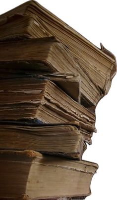 a stack of old books sitting next to each other on top of a white surface