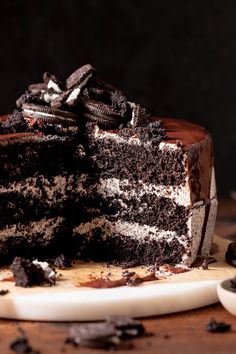 a chocolate cake with oreo cookies on top and one slice cut from the cake