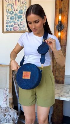 a woman in shorts and a white shirt is holding two pieces of blue fabric on her back