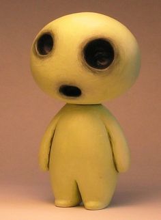 a small yellow toy with big eyes on it's head