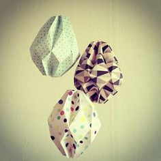 three hats hanging from the ceiling with polka dot designs on them and one is white