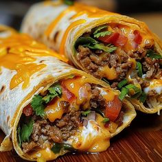 two burritos with meat and cheese are on a cutting board, ready to be eaten