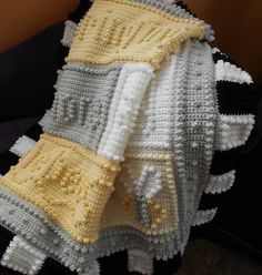 a crocheted blanket sitting on top of a couch