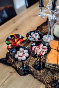 small trays filled with candy sitting on top of a table next to a candle