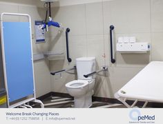 a white toilet sitting in a bathroom next to a sink and bathtub with blue handles