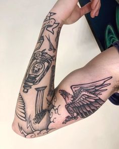 a man's arm with tattoos on it and an eagle holding a clock in the air