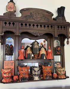 an old wooden shelf with many halloween figurines on it