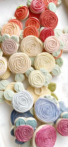 colorful cupcakes are arranged on a white surface