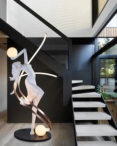 a white sculpture sitting on top of a wooden floor next to a stair case in a living room