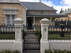 a house with a black iron fence and white pillars