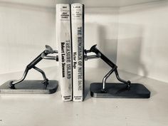 two bookends made out of metal sitting next to each other