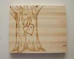 a wooden plaque with a heart carved on it's side next to a tree