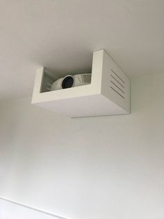 an overhead view of a camera mounted to the ceiling in a room with white walls