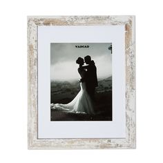 a white frame with a black and white photo of a bride and groom in the mountains